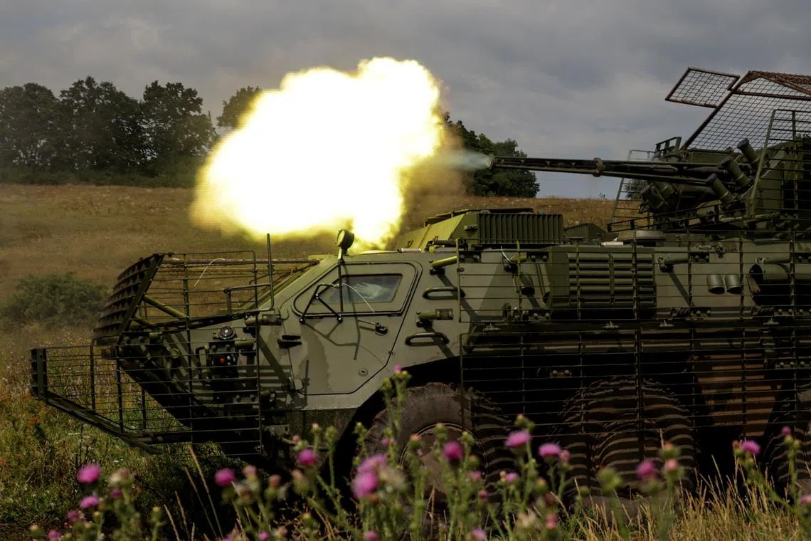 FILE PHOTO: Service members of the 58th Separate Motorized Infantry Brigade of the Ukrainian Armed Forces fire a cannon of a BTR-4 armoured personnel carrier during military exercises at a training ground, in Kharkiv region, Ukraine, August 11, 2025. REUTERS/Sofiia Gatilova/File Photo
