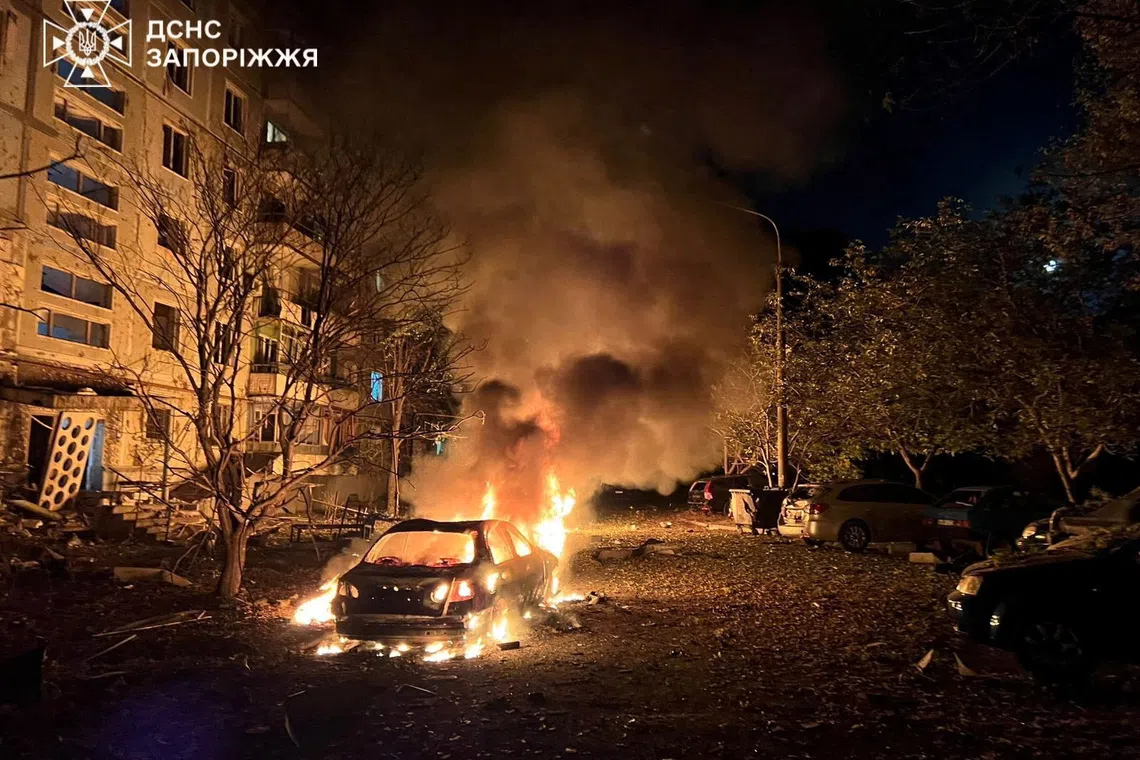 A car burns in front of an apartment building damaged during overnight Russian drone and air strikes, amid Russia's attack on Ukraine, in Zaporizhzhia, Ukraine October 5, 2025. Press service of the State Emergency Service of Ukraine in Zaporizhzhia region/Handout via REUTERS ATTENTION EDITORS - THIS IMAGE HAS BEEN SUPPLIED BY A THIRD PARTY. DO NOT OBSCURE LOGO.