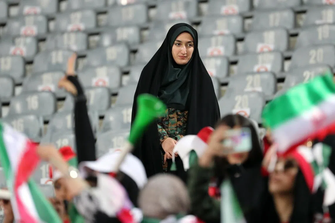 An Iranian policewoman watches fans during a friendly soccer match between Iran and Kenya, in Teheran.