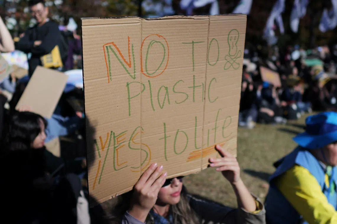 A woman holds up a sign during a rally to demand stronger global commitments to fight plastic waste at the upcoming fifth session of the Intergovernmental Negotiating Committee (INC-5), in Busan, South Korea, November 23, 2024.   REUTERS/Daewoung Kim