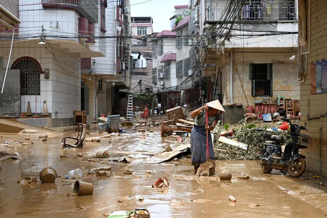 A resident cleaning up a street after heavy rainfall led to flooding, in Huaiji county of Zhaoqing, Guangdong province, China, on June 19, 2025. 
