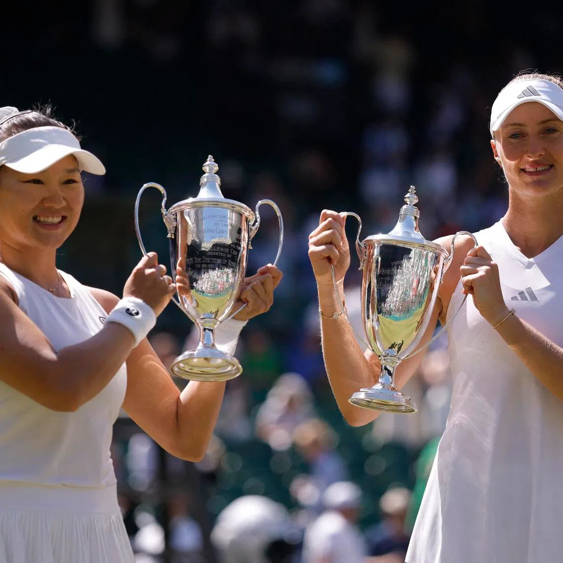 Tennis - Wimbledon - All England Lawn Tennis and Croquet Club, London, Britain - July 12, 2026 General view as China's Guo Hanyu and France's Kristina Mladenovic celebrate with the trophies after winning their women's doubles final match against Canada's Gabriela Dabrowski and Brazil's Luisa Stefani REUTERS/Andrew Couldridge