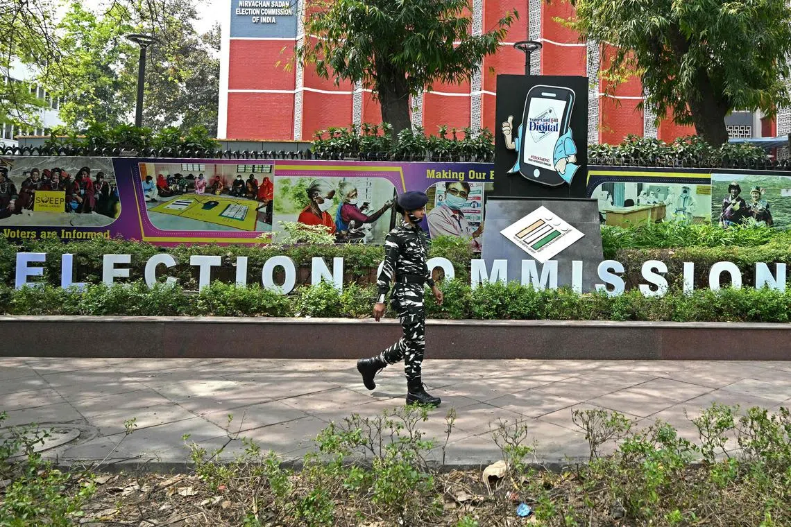 An Indian security personnel walks past the office of the Election Commission of India, ahead of country's upcoming general elections, in New Delhi on April 15, 2024. Nearly a billion Indians will vote to elect a new government in six-week-long parliamentary polls starting on April 19, the largest democratic exercise in the world. (Photo by Money SHARMA / AFP)