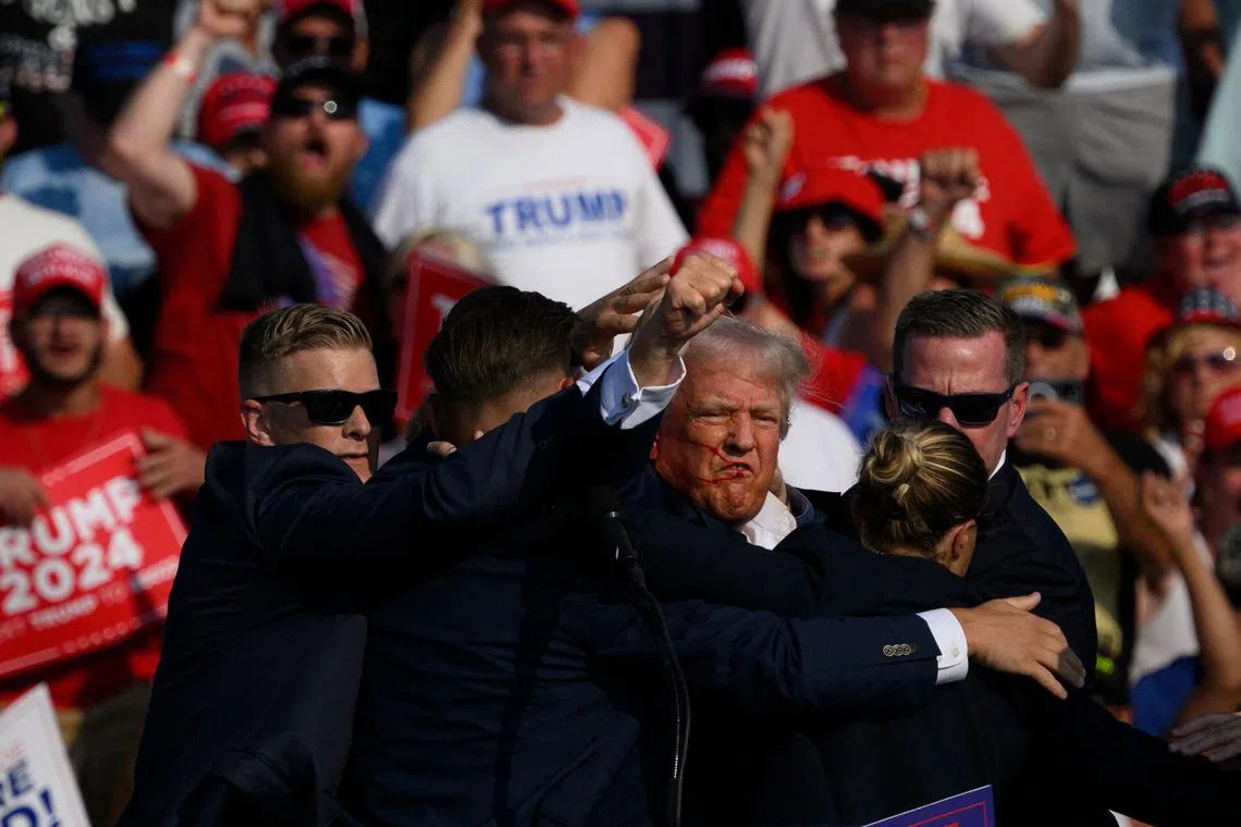 Former US President Donald Trump is whisked away by Secret Service after shots rang out at a campaign rally in Butler, Pennsylvania, on July 13.
