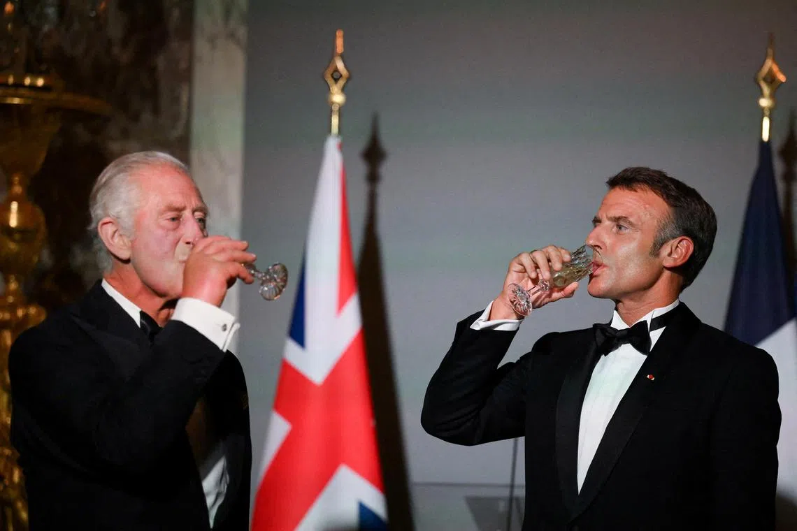 FILE PHOTO: Britain's King Charles and French President Emmanuel Macron drink after a toast during a state banquet at the Palace of Versailles, west of Paris, on September 20, 2023, on the first day of a British royal state visit to France. DANIEL LEAL/Pool via REUTERS/File Photo