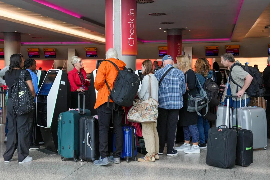 FILE PHOTO: Passengers queue for the assistance with self check-in machines at Heathrow Terminal 3 in London, Britain, August 22, 2023. REUTERS/Maja Smiejkowska/File Photo