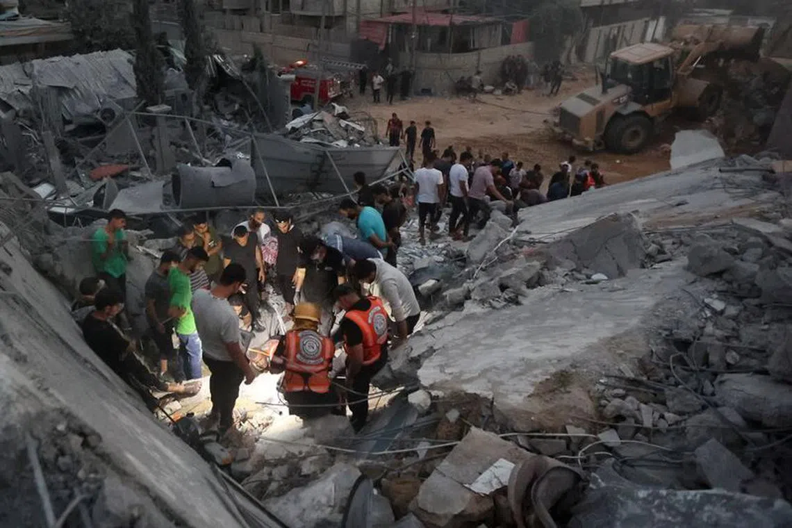 Palestinians search for casualties at the site of Israeli strikes on a residential building, in the central Gaza Strip October 31, 2023. REUTERS/Ahmed Zakot