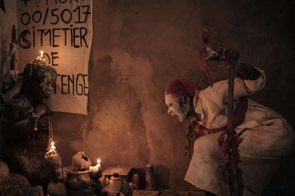 The 'voodoo' wrestler known as Panthère uttering incantations above the alter of his shrine in Kinshasa, Democratic Republic of Congo, on July 27, 2023. In the capital of DR Congo, dozens of men and women, including former wrestlers practice 'voodoo wrestling', using traditional fetishes and animals. Fights are organised in some of the city's poorest and most densely populated 