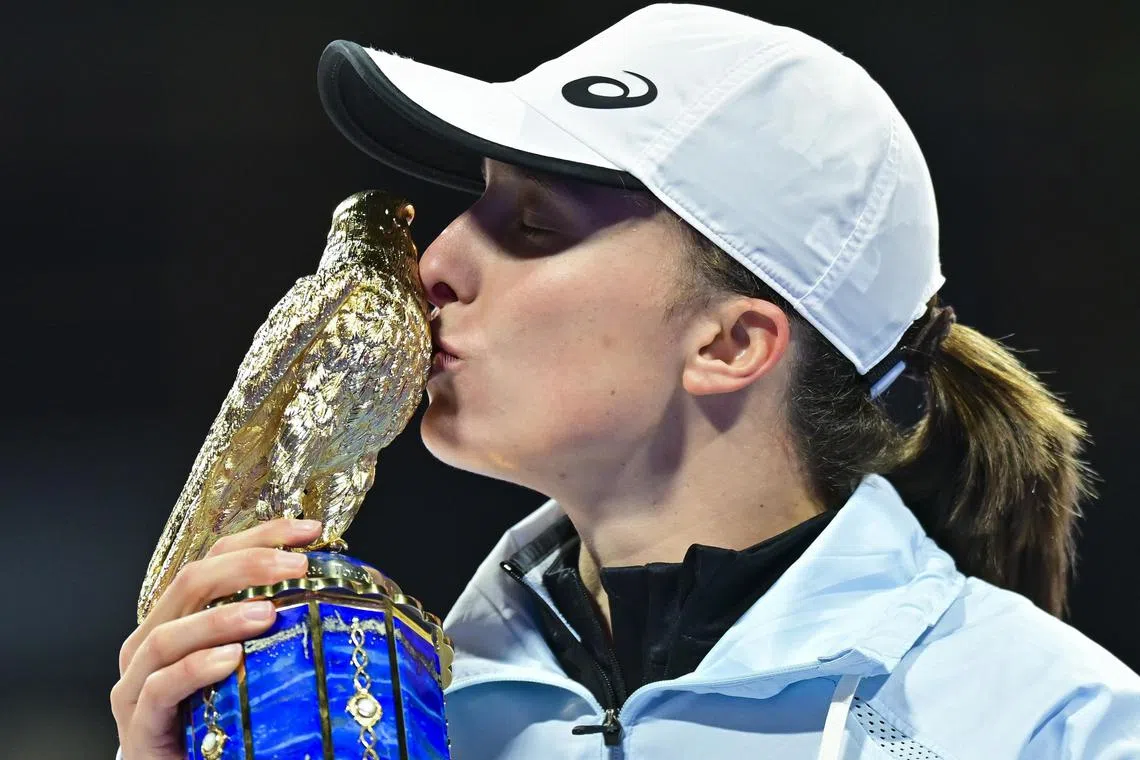 Poland's Iga Swiatek poses with the trophy after winning the Qatar  Open final against Jessica Pegula of US.