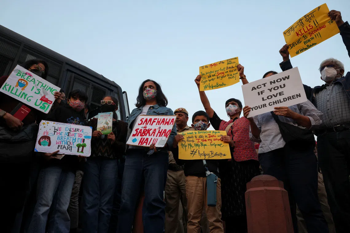 Protesters hold placards in front of the India Gate during a protest against air pollution in New Delhi, India, November 9, 2025. REUTERS/Bhawika Chhabra