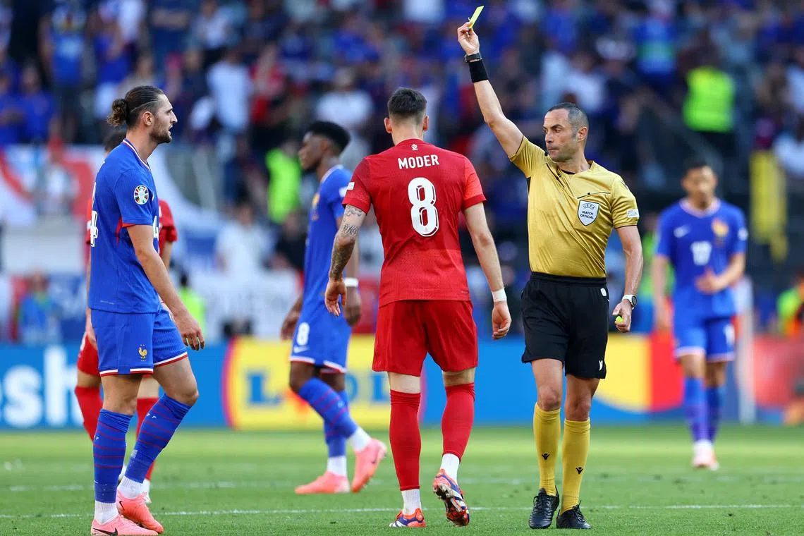 Soccer Football - Euro 2024 - Group D - France v Poland - Dortmund BVB Stadion, Dortmund, Germany - June 25, 2024 France's Adrien Rabiot is shown a yellow card by referee Marco Guida REUTERS/Bernadett Szabo