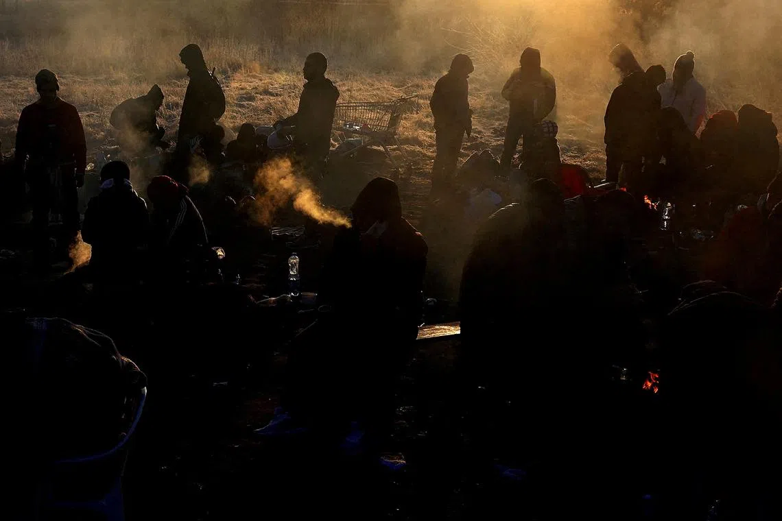 FILE PHOTO: Refugees brave the cold in a frozen field after they fled from Ukraine because of the Russian invasion at the border checkpoint in Medyka, Poland, March 1, 2022.   REUTERS/Kai Pfaffenbach/File Photo