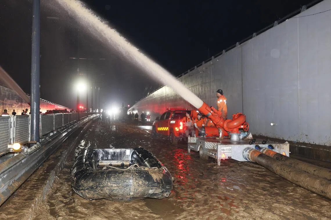 Rescue workers pump water out of a flooded underground tunnel in the town of Osong, North Chungcheong Province, on July 17.