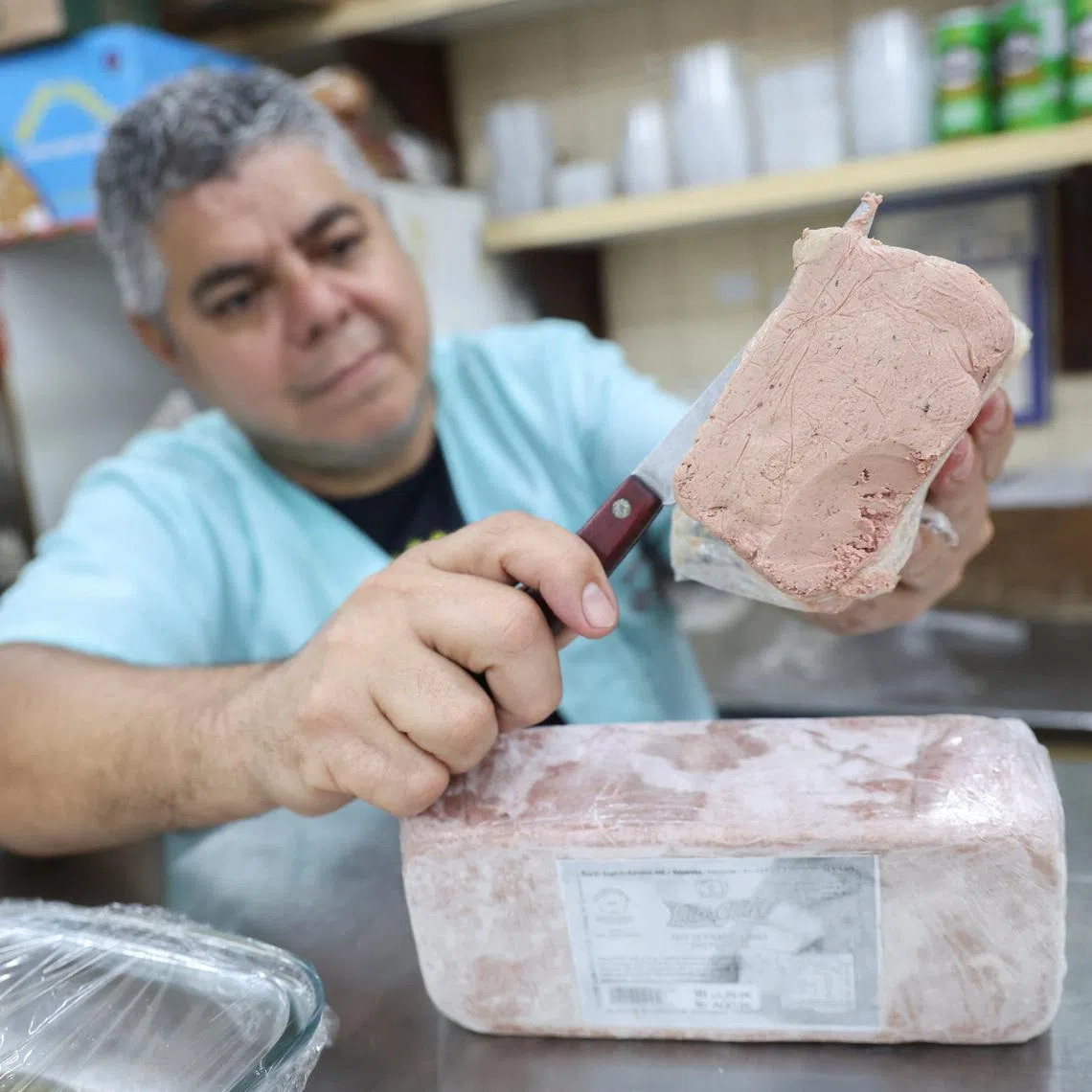 A vendor slices a pate of foie gras at a shop in Rio de Janeiro, Brazil, July 24, 2026, after President Luiz Inacio Lula da Silva signed a law banning the production and sale of the French delicacy in the South American country, citing animal cruelty concerns. REUTERS/Aline Massuca