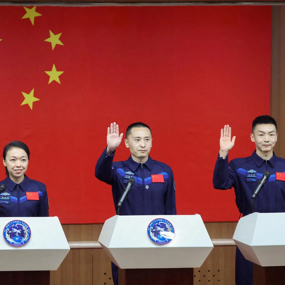 Astronauts Zhu Yangzhu, Zhang Zhiyuan, and Lai Ka-ying, who is the first astronaut from Hong Kong, gesture as they attend a press conference before the Shenzhou-23 spaceflight mission to China's Tiangong space station, at Jiuquan Satellite Launch Center, near Jiuquan, Gansu province, China, May 23, 2026. REUTERS/Maxim Shemetov