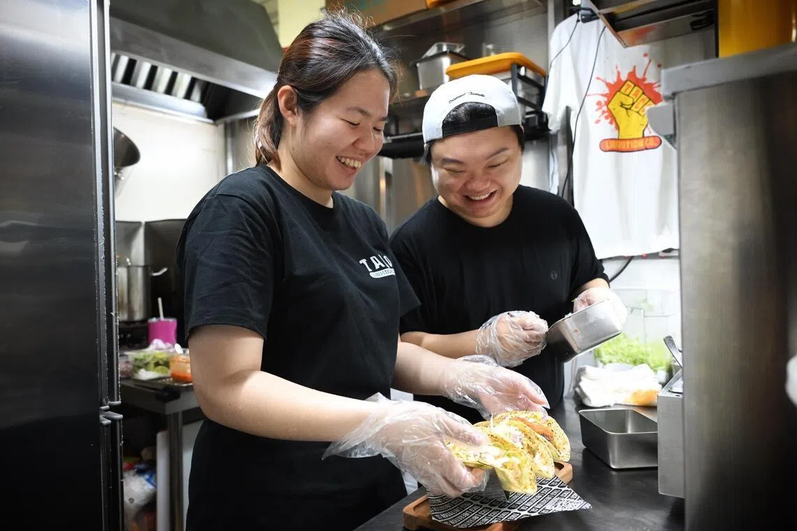 Ms Veronica Liew and Mr Ong Ziqi preparing tacos at their hawker stall in Amoy Street Food Centre. 