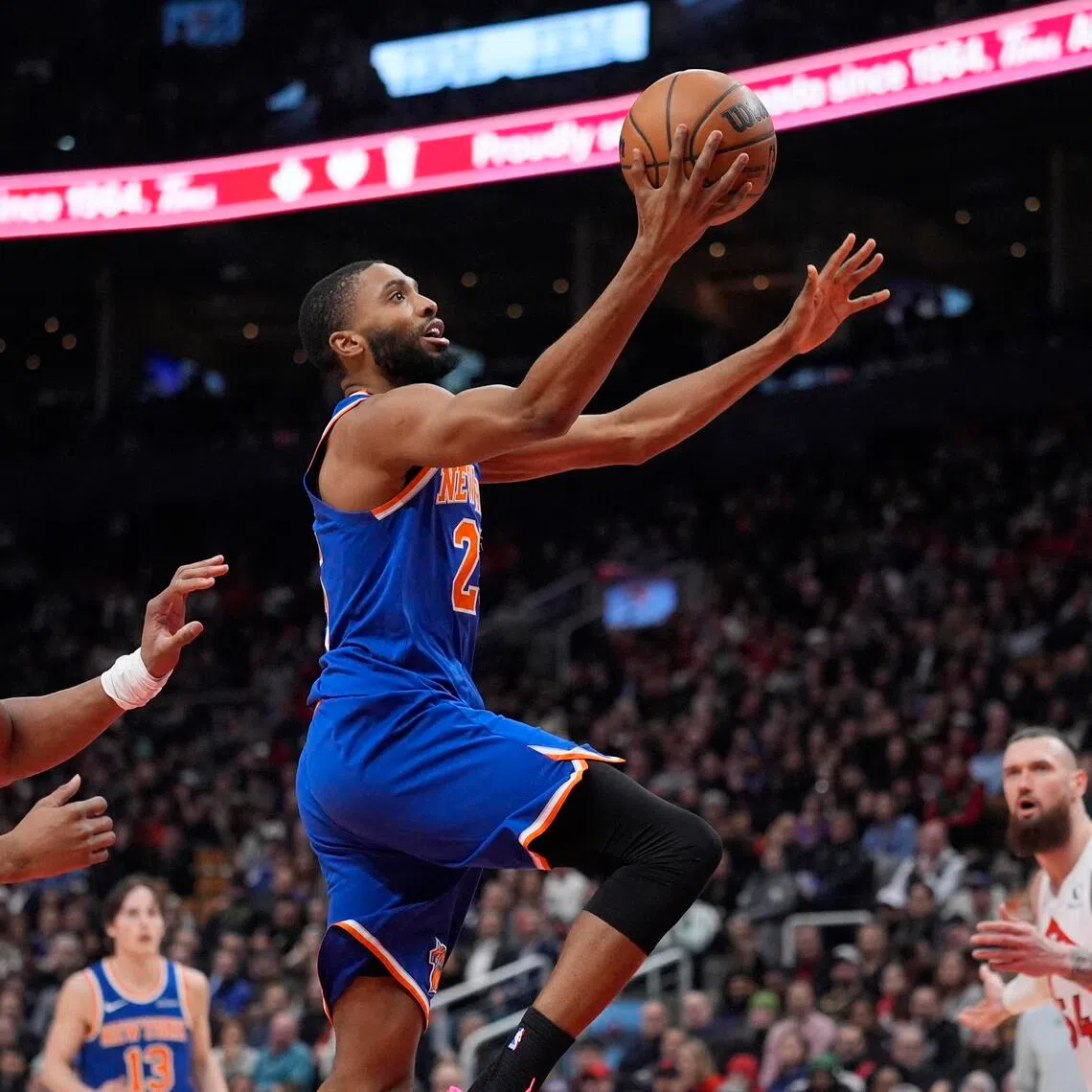 New York Knicks guard Mikal Bridges goes up to make a basket against Toronto Raptors guard Scottie Barnes during the first half at Scotiabank Arena. 
