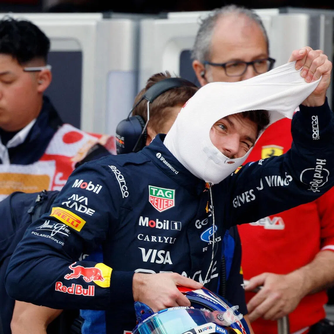 TOPSHOT - Red Bull Racing's Dutch driver Max Verstappen takes off his balaclava in the pits during the qualifying session ahead of the Formula One Japanese Grand Prix at the Suzuka circuit in Suzuka, Mie prefecture on March 28, 2026. (Photo by FRANCK ROBICHON / POOL / AFP)