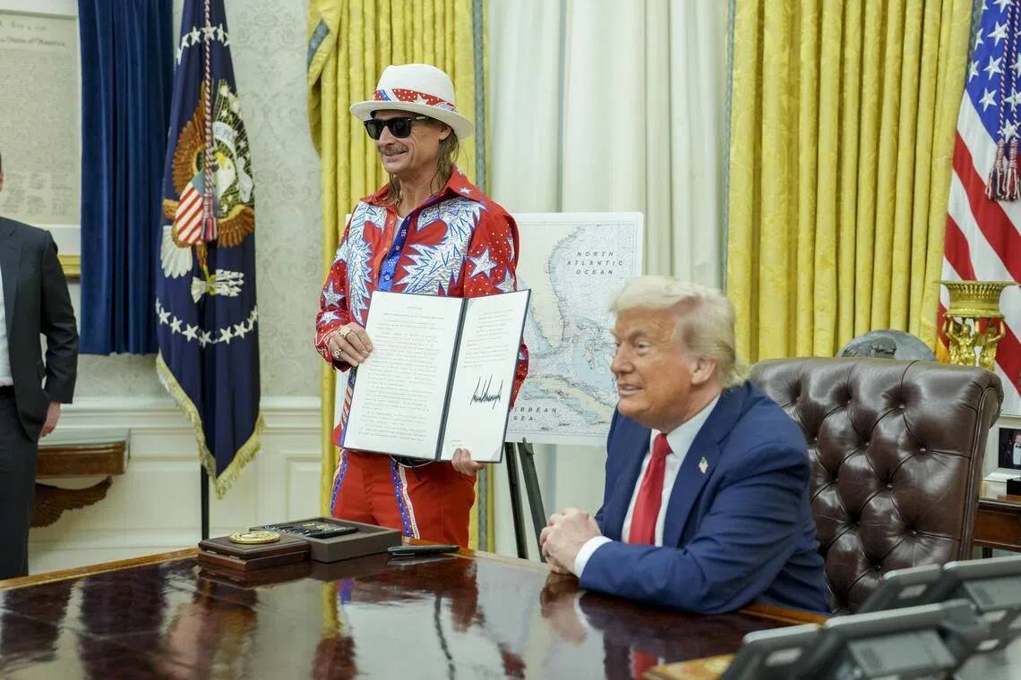 US President Donald Trump, alongside the singer Kid Rock, makes remarks as he signs executive orders in the Oval Office of the White House in March 2025.