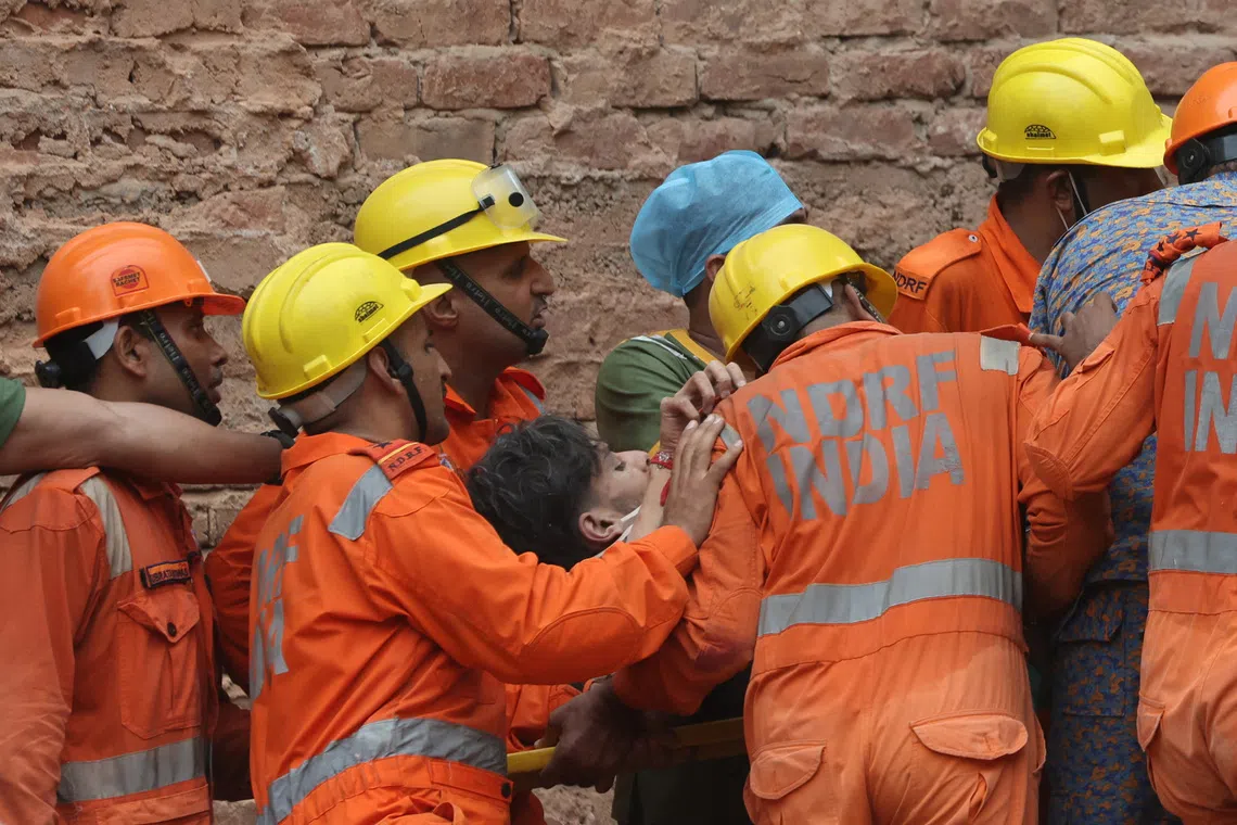 Members of a rescue team carry a victim after a building collapsed in New Delhi, India, September 6, 2026. REUTERS/Bhawika Chhabra