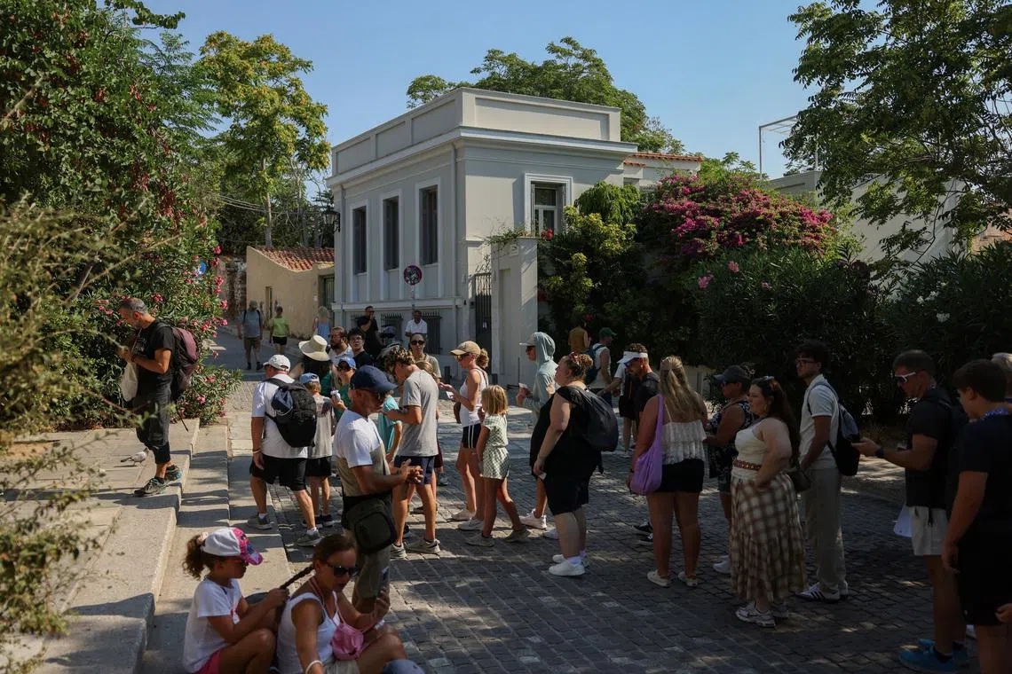 Tourists wait in line to enter the Acropolis archaeological site near the location where two American tourists were stabbed in Athens, Greece, July 21, 2026. REUTERS/Louiza Vradi