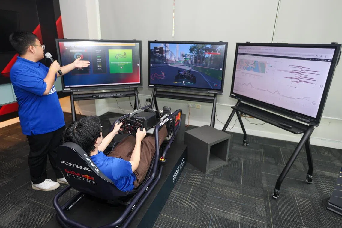 Temasek Polytechnic Big Data and Analytics second-year student Billy Lim Xiao Xi (right), alongside his course mate Khant Thu John, demonstrating the use of the simulator at the school’s DRIVE lab on Oct 6.