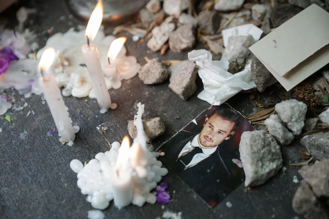 A picture of Liam Payne lays next to lit candles outside the hotel where Liam Payne, former One Direction band member, was found dead after he fell from a third-floor hotel room balcony, in Buenos Aires, Argentina, October 17, 2024. REUTERS/Tomas Cuesta