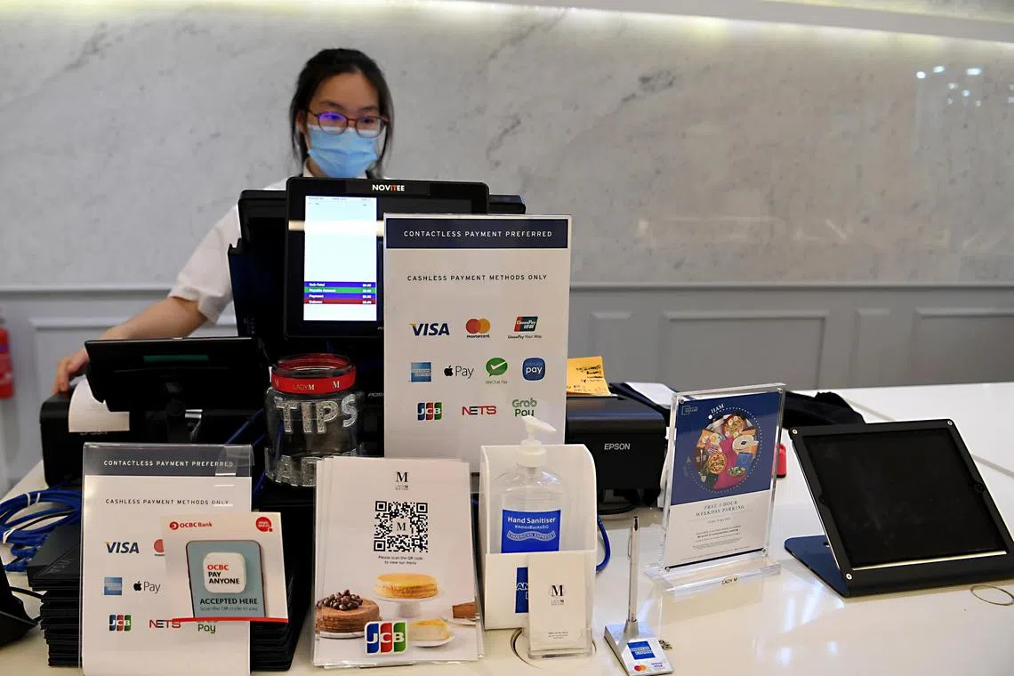 Signs in front of the cashier counter at Lady M at Scotts Square as a reminder that they only accept cashless payments.