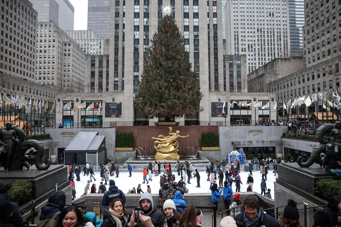 People stand in front of the Rockefeller Center Tree on Christmas Day in Manhattan in New York City, U.S., December 25, 2024. REUTERS/Marko Djurica