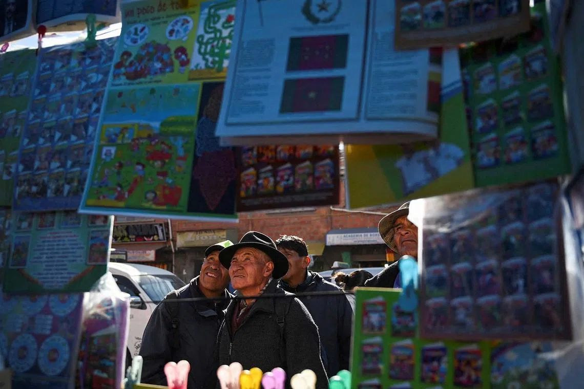 People looking at the front pages of newspapers covering Bolivia's presidential election in El Alto, Bolivia, Aug 18, 2025. 