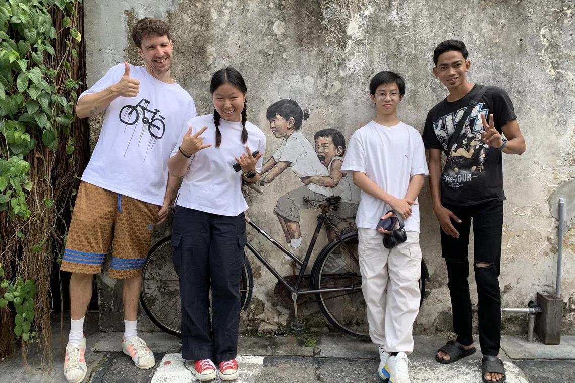 (From left) Lithuanian artist Ernest Zacharevic, siblings Tan Yi and Tan Kern, and Mohammad Shahrul Aiman Mohamed in Penang recently. 