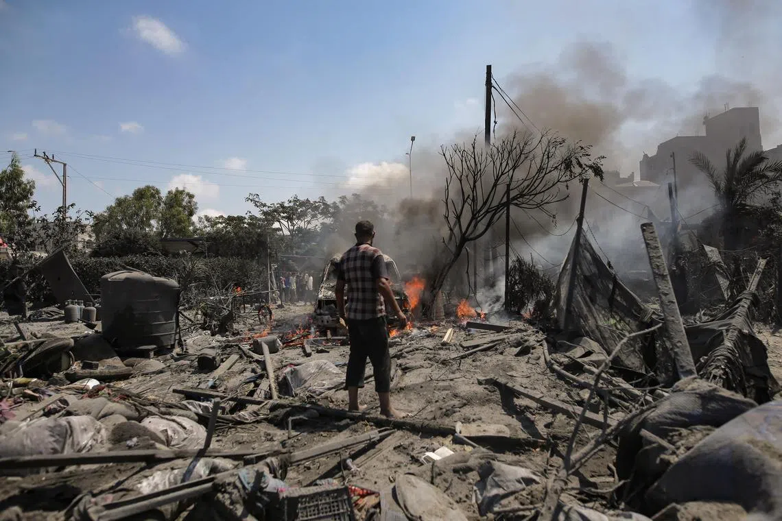 Palestinians inspect the scene after an Israeli raid on the Al-Mawasi area of Khan Younis, in the southern Gaza Strip.