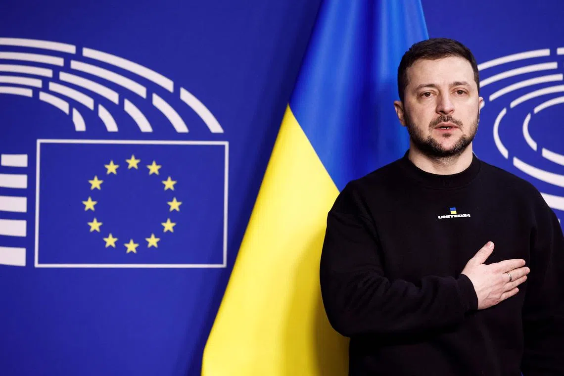 Hand on his heart, standing in front of the blue and yellow Ukrainian flag while his country’s national anthem played in the European Parliament, Mr Zelensky prepared to address the assembly before attending a summit of EU leaders.
