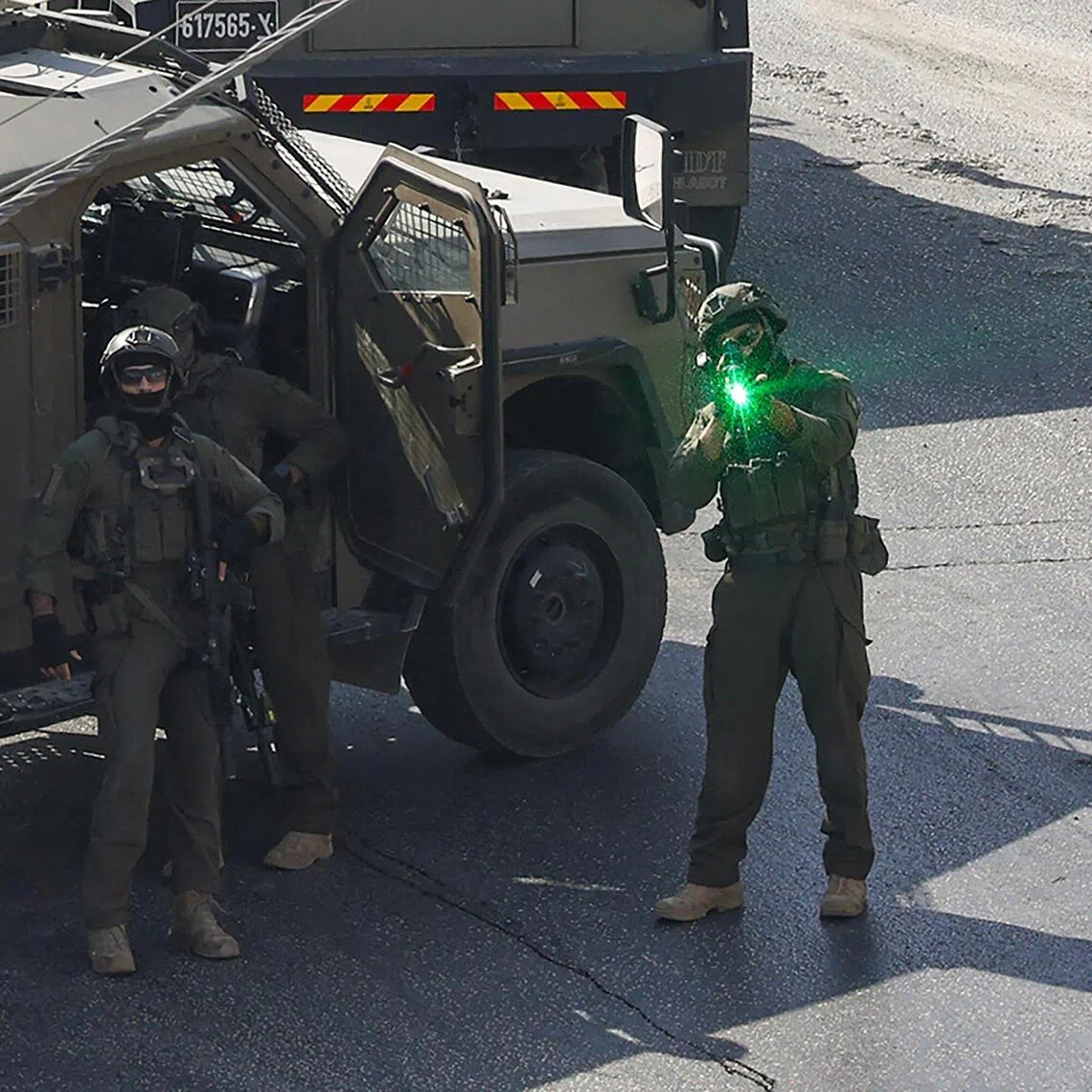 An Israeli soldier aiming his weapon as security forces patrol the Israeli-occupied West Bank city of Hebron, where Palestinian gunmen killed two soldiers, on Oct 23.
