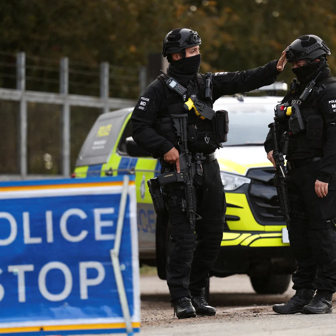 Armed police officers work on a road outside the perimeter of the RAF Fairford airbase, after police declared a major incident at the base after several men were arrested on suspicion of offences under the Explosives Act, in Fairford, Gloucestershire, Britain, September 28, 2026. REUTERS/Toby Shepheard
