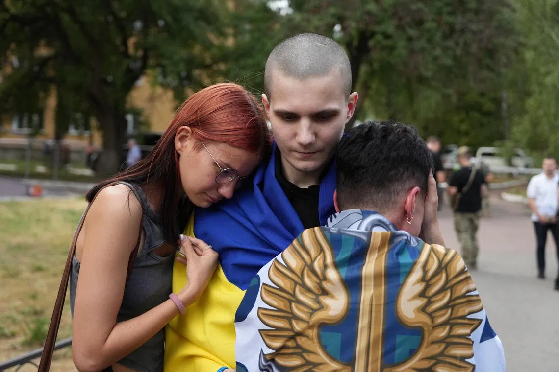Ukrainian prisoners of war are welcomed home by relatives and military personnel, at an undisclosed location in Ukraine on Sept 13.
