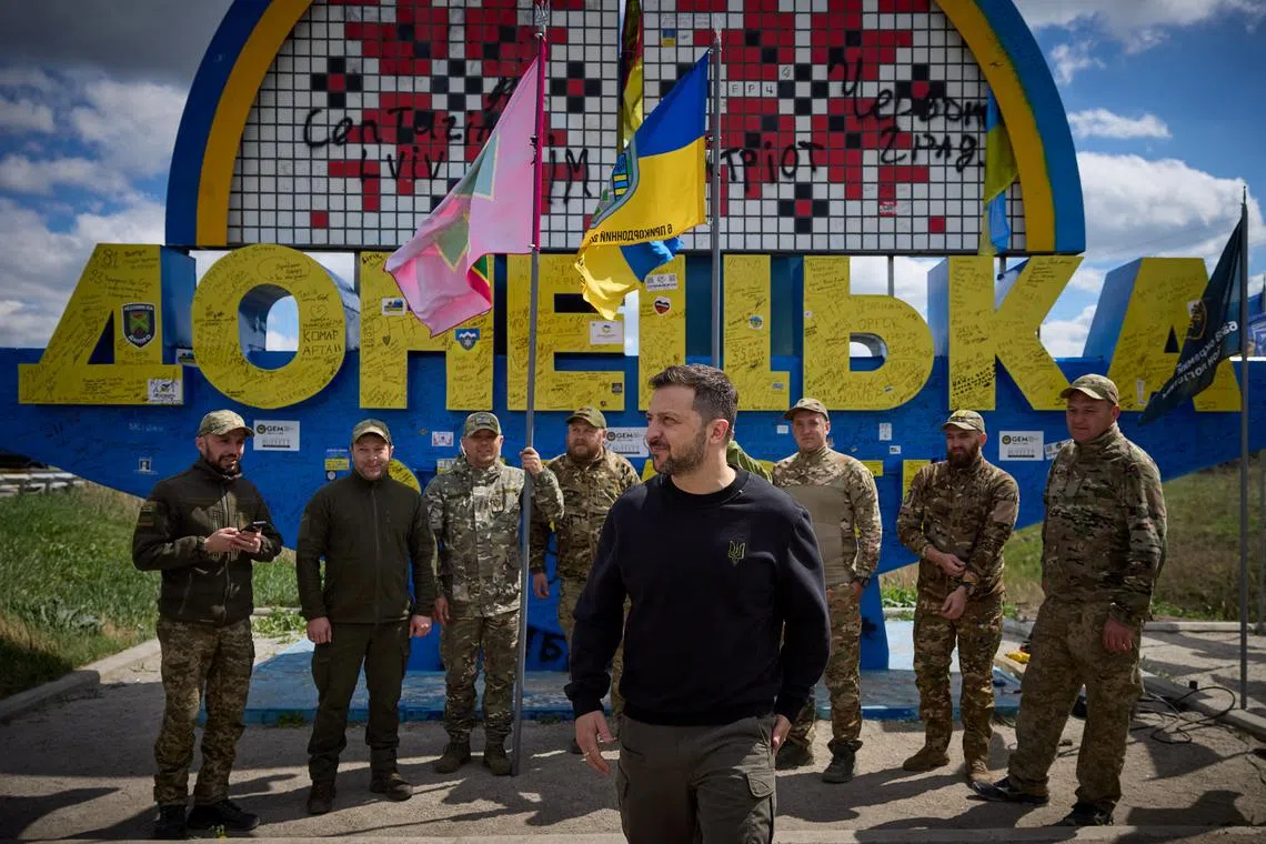 Ukraine's President Volodymyr Zelenskiy appears with Ukrainian servicemen in front of a road sign ’Donetsk region’, amid Russia's attack on Ukraine, in Donetsk region, Ukraine, April 19, 2024. Ukrainian Presidential Press Service/Handout via REUTERS ATTENTION EDITORS - THIS IMAGE HAS BEEN SUPPLIED BY A THIRD PARTY.