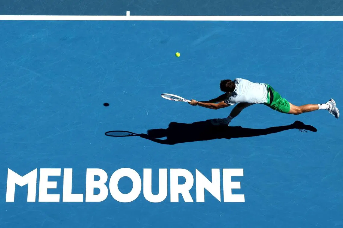 Russia's Daniil Medvedev hits a return against Thailand's Kasidit Samrej during their Australian Open first-round clash.
