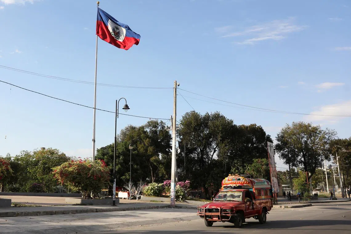 FILE PHOTO: A vehicle drives past Haiti's national flag, in Port-au-Prince, Haiti February 9, 2021. REUTERS/Valerie Baeriswyl/File Photo