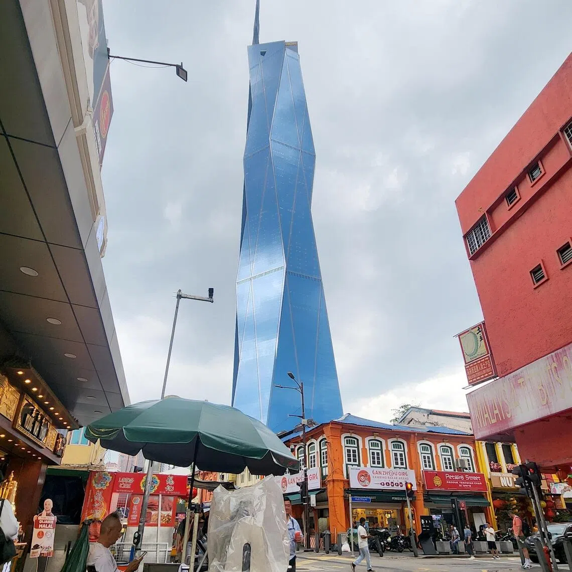 The blue Merdeka 118 skyscraper soars above Chinatown in central Kuala Lumpur.
