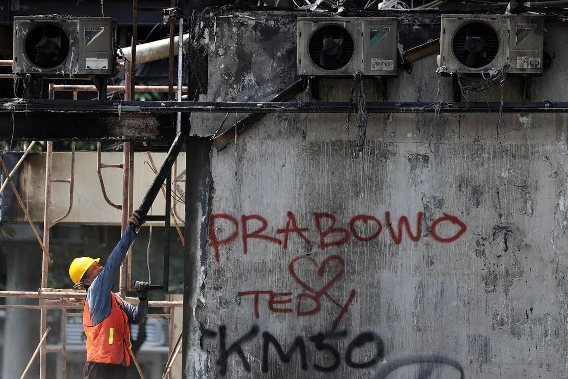 A municipality worker cleans debris at a burned bus stop on Sept 2, 2025, in the aftermath of protests in Jakarta, Indonesia. 