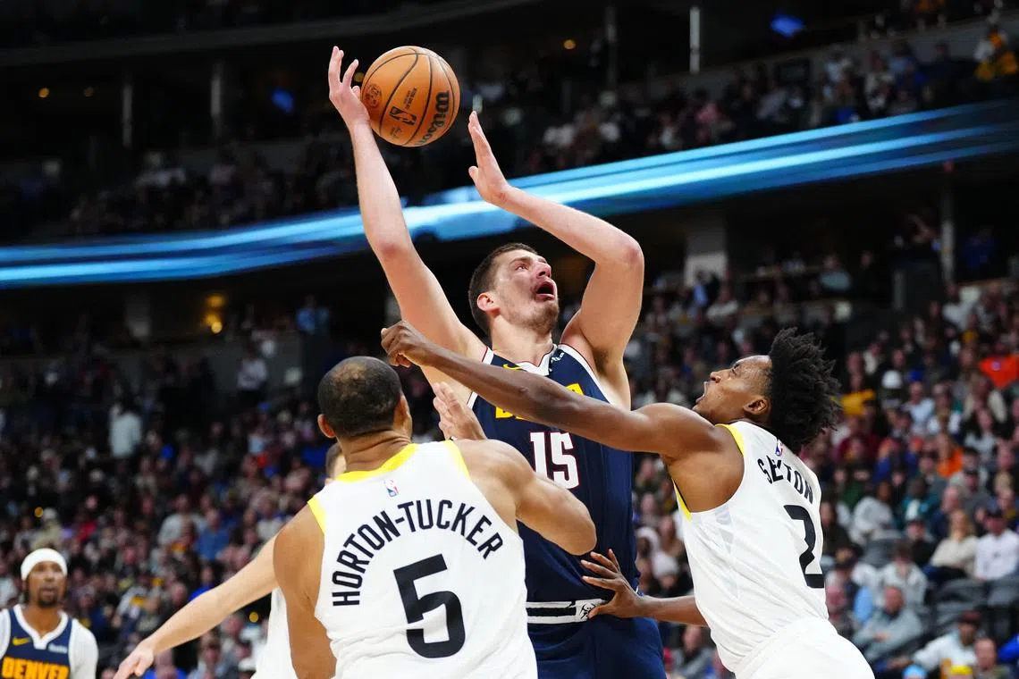 Utah Jazz guard Collin Sexton fouling Denver Nuggets centre Nikola Jokic in the second half at Ball Arena on Sunday. Jokic finished with 27 points, 11 assists and 10 rebounds in his side's 110-102 NBA win.