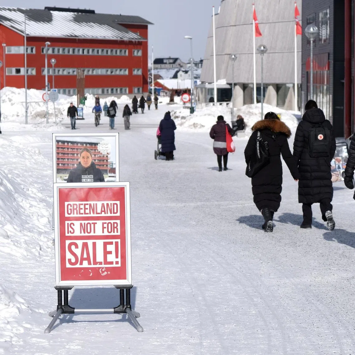 People walk past posters for candidates in the upcoming Danish elections in Nuuk, Greenland, March 17, 2026. REUTERS/Tim Barsoe