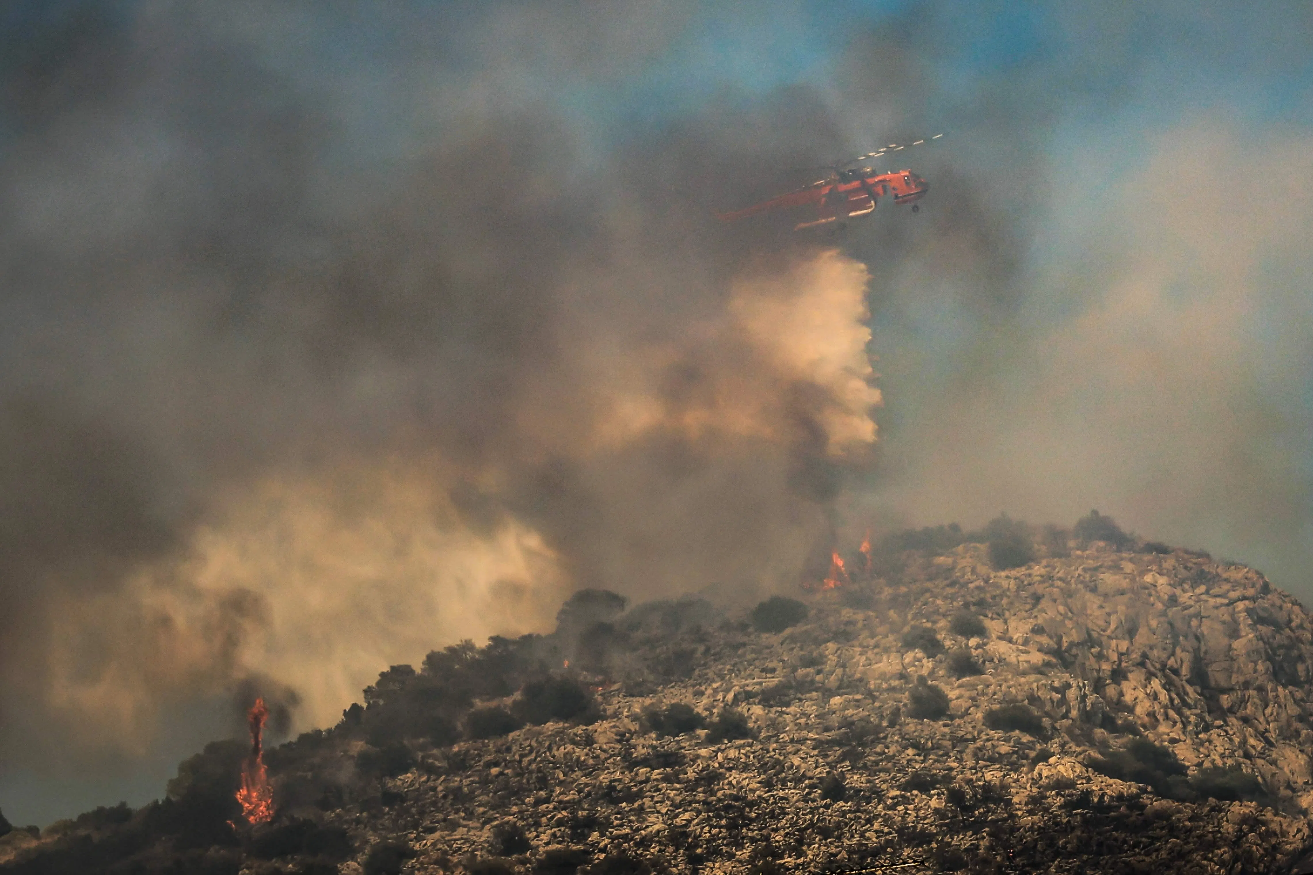 A firefighting helicopter dropping water on the flames on the Salamina on Aug 16. The island has some 37,000 residents, many of them elderly.