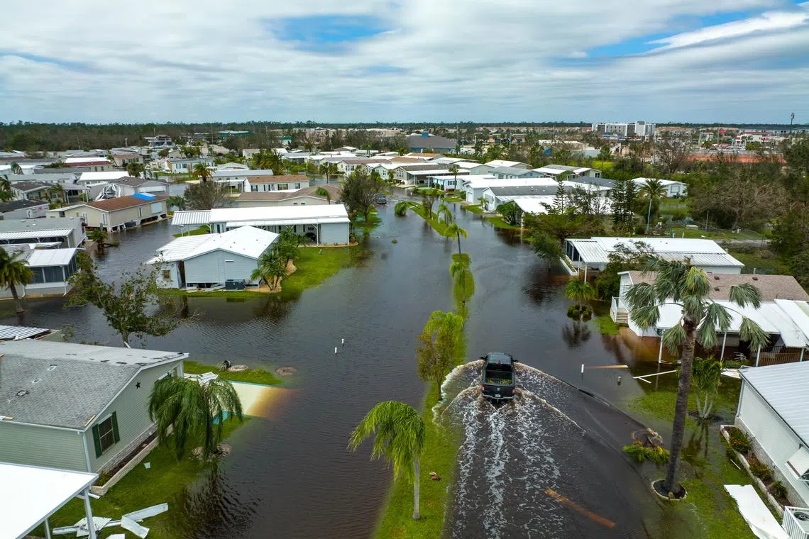 A truck drives through a flooded subdivision in Port Charlotte, Florida, the day after Hurricane Ian made landfall, on Sept 29, 2022. 