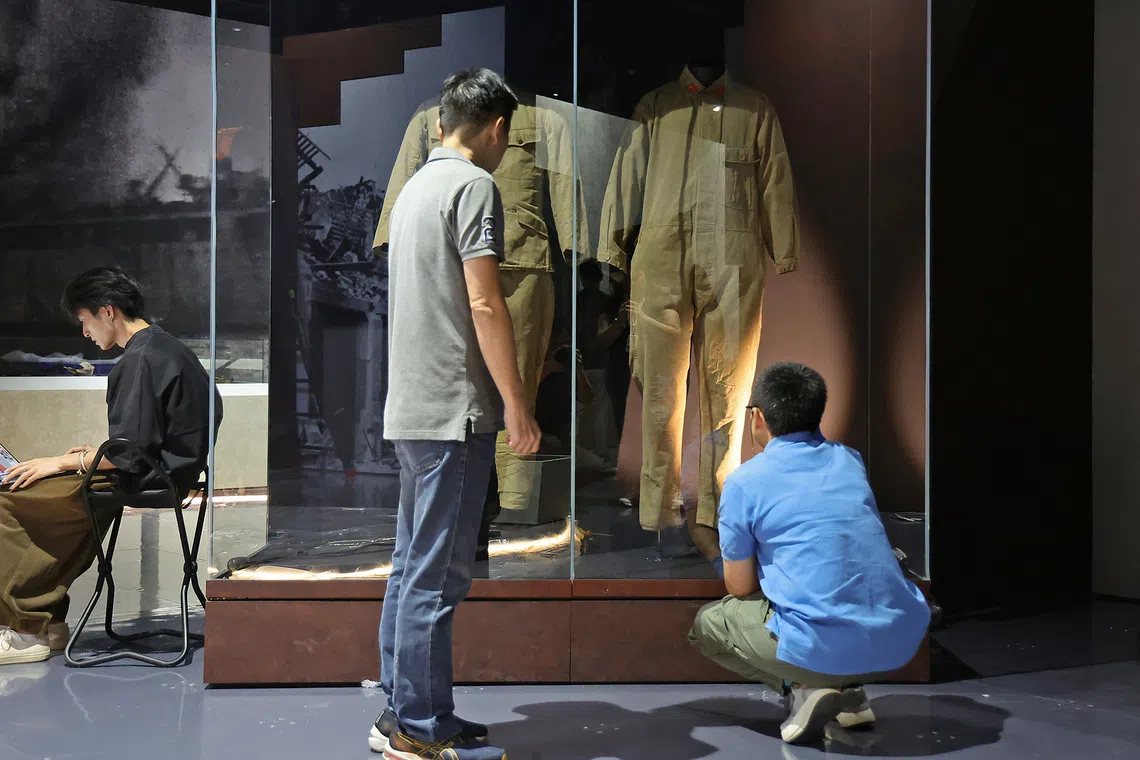National Museum’s exhibitions team checking the display and installation of a Japanese soldier’s khaki uniform and tank crew overall from the 1940s in the Fall of the Fortress section of the gallery on Aug 20, 2026. 
