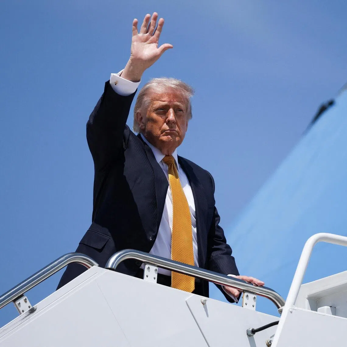 US President Donald Trump waves as he boards Air Force One, bound for China, on May 12.