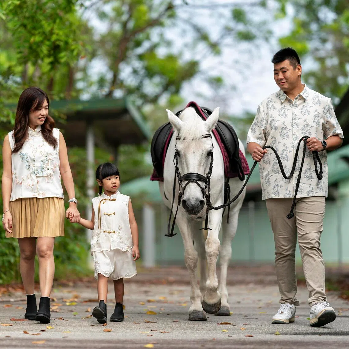 Ms Zann Chin, her husband Ting Min Long and their daughter Zaelyn posing for a family photograph with Molly the horse at Bukit Timah Saddle Club on Feb 18.