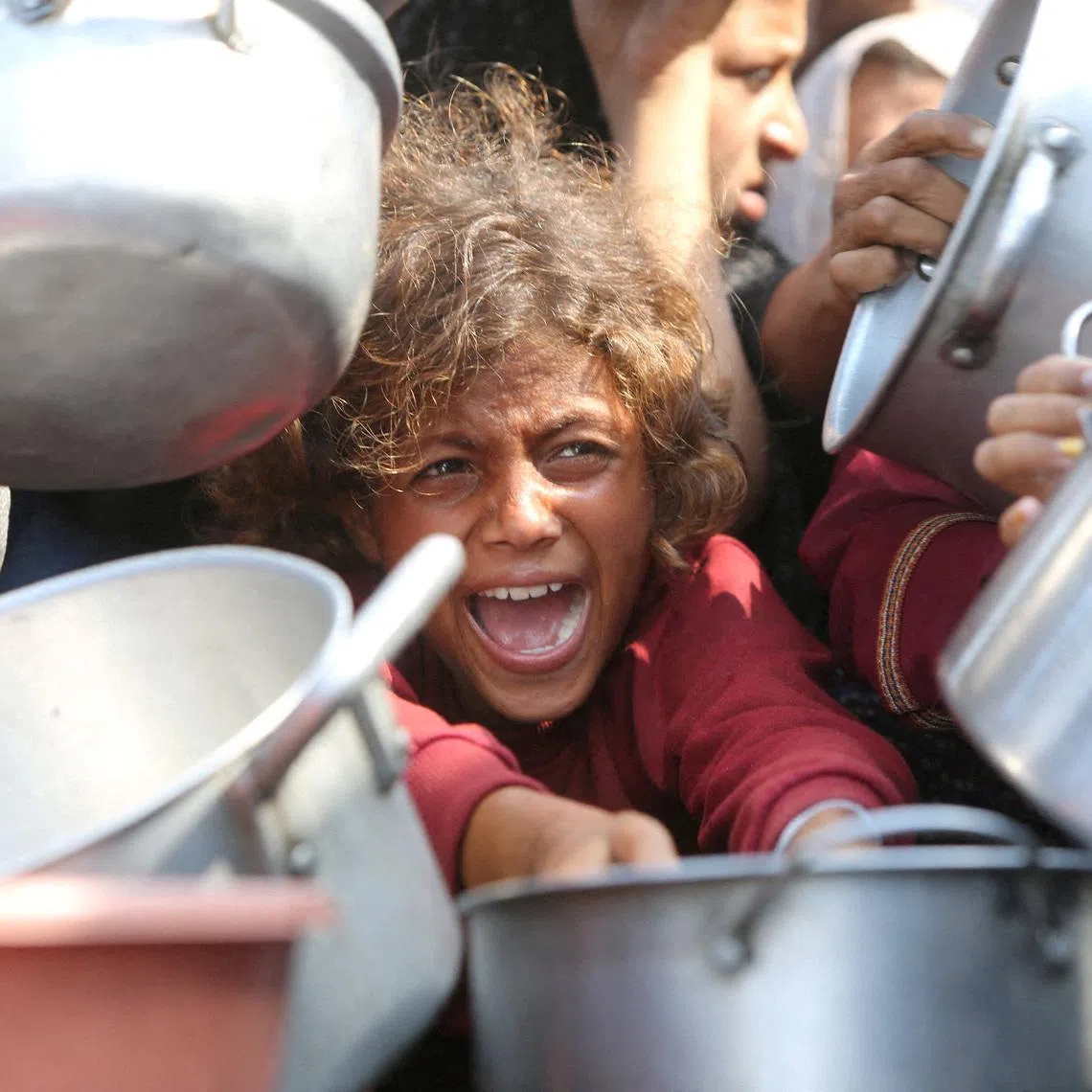 Palestinians clamouring for food from a charity kitchen in the southern Gaza Strip in August 2025.