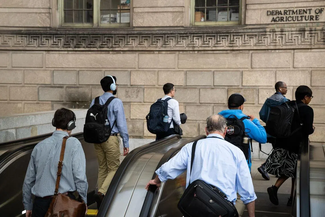 Commuters outside the Smithsonian National Mall Metro Station near a Department of Agriculture office building in Washington, DC, US, on Thursday, May 1, 2025. Federal employee pension benefits are set to be pared back in Republicans' giant tax and spending package working its way through the US House, another slap at a workforce roiled by Elon Musk's cost-cutting efforts. Photographer: Graeme Sloan/Bloomberg